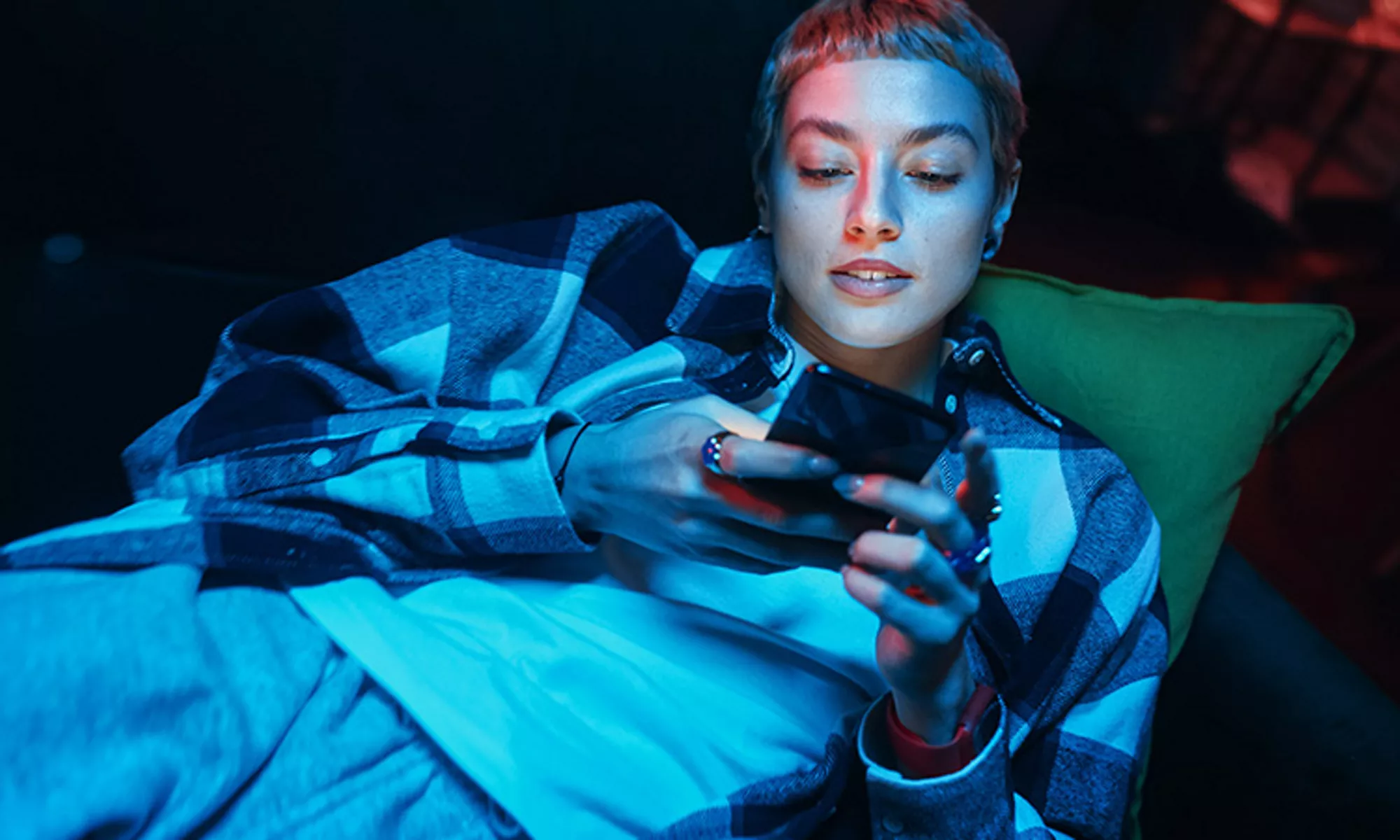 person typing on smart phone at night