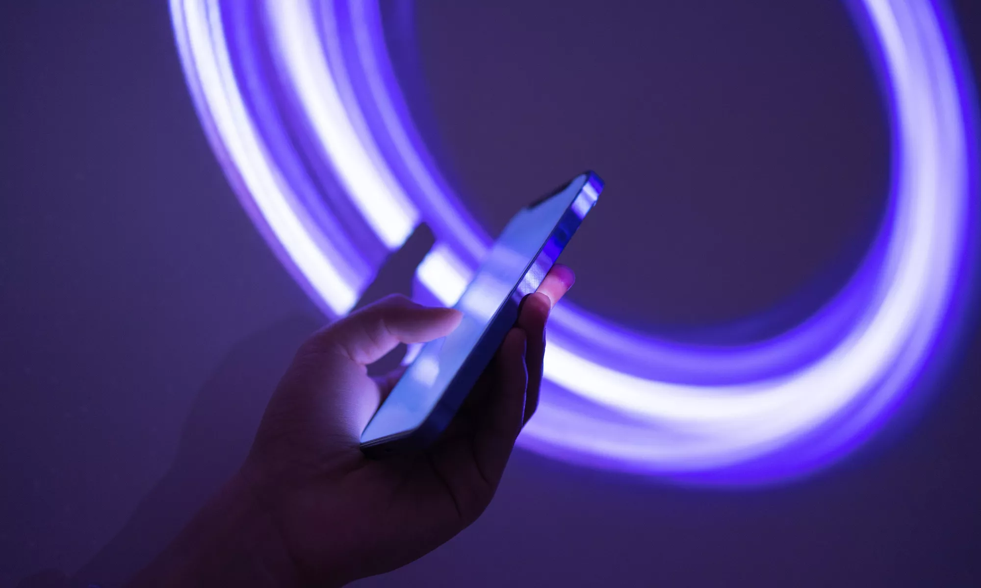 Phone being used with neon blue circular lines as background